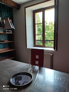 Una mesa de comedor con un cuenco encima frente a una ventana. en cosy, zen, télétravail cool, en Ville-sur-Yron 3 fotos más