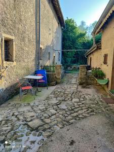 un patio de piedra con mesa y sillas junto a un edificio en cosy, zen, télétravail cool, en Ville-sur-Yron