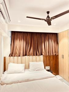a bedroom with a bed with a ceiling fan at Prince NX Hotel in Thane +49 photos