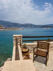 a wooden bench sitting next to the water at Agnanti Studios in Meyisti