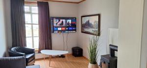 a living room with a tv on the wall at Storgata 78, Leknes sentrum in Leknes