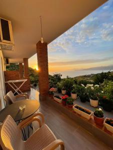 a balcony with a table and chairs and plants at Grand Seaview Apartments in Ksamil
