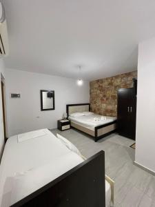 a bedroom with two beds and a tv in it at Grand Seaview Apartments in Ksamil