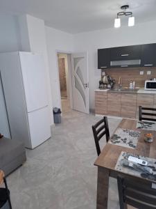 a kitchen with a table and a white refrigerator at Apartment Active Sport in Pazardzhik +6 photos
