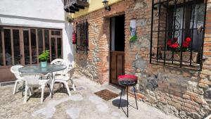 a patio with a table and chairs and a grill at La Casina de la Caleyona, Parres - Llanes in Llanes