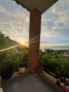 a brick pillar on a balcony with plants and the sunset at Grand Seaview Apartments in Ksamil