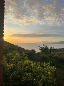 a view of the ocean at sunset from a house at Grand Seaview Apartments in Ksamil
