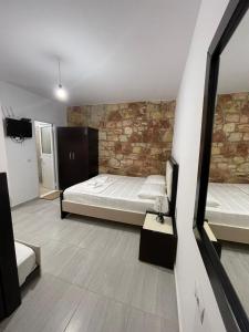 a bedroom with a bed and a brick wall at Grand Seaview Apartments in Ksamil