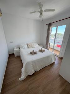 Un dormitorio con una cama blanca con dos toallas encima. en Can Xubec, en Cala'n Bosch