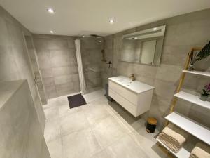 a white bathroom with a sink and a mirror at Studio Alexander with private indoor parking in Zandvoort