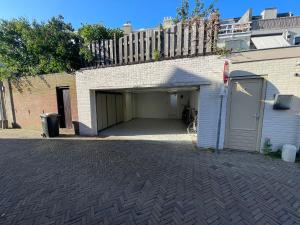 a garage with a garage door next to a brick building at Studio Alexander with private indoor parking in Zandvoort