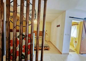 QalaにあるGozo - Large terrace, splendid viewsの木の棒が置かれた部屋にあるベッドのある寝室