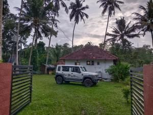 a white jeep parked in front of a house at canan lake home in Parattipalli