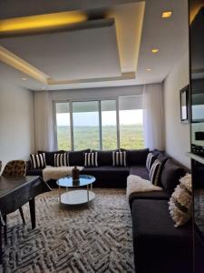 een woonkamer met een bank en een tafel bij Bella Vista MEHDIA in Kenitra