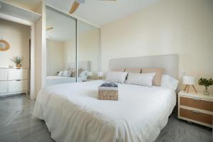 una camera da letto con un grande letto bianco con uno specchio di Vistamar Laguna Beach a Torrox Costa Altre 39 foto