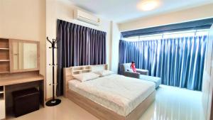 a bedroom with a bed and a window with blue curtains at Family House Casa Seaside Rayong in Ban Chak Phai +13 photos