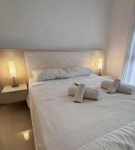 ein großes weißes Bett mit zwei Kissen darauf in der Unterkunft Hogar Feliz de España in Ciudad Quesada + 9 Fotos