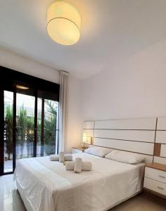 ein weißes Schlafzimmer mit einem großen Bett und einem großen Fenster in der Unterkunft Hogar Feliz de España in Ciudad Quesada