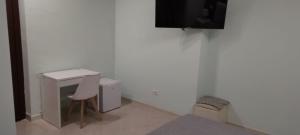escritorio blanco con silla y TV en la pared en Suite Conte di Cavour, en Palermo