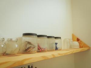 a row of glass jars sitting on a shelf at Mama Killa Studio,1BHK,Apartment in Pushkar