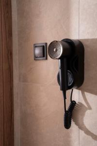 un téléphone sur un mur à côté d'une douche dans l'établissement Palm Suites, à Nea Vrasna