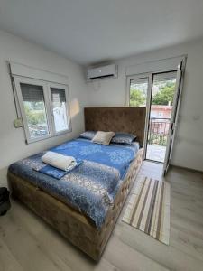 a bedroom with a large bed with blue sheets and pillows at Spasic Apartments Sutomore in Sutomore