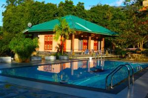 a resort with a swimming pool and a building at World's End Base Eco-Village in Belihuloya