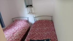 two beds sitting next to each other in a room at Sunny49 in Caeathro