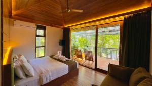 a bedroom with a bed and a view of a balcony at Chembarathi Wayanad Boutique Resort in Vaduvanchal