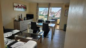 una sala de estar con una mesa y sillas en Le Grand bleu, en Valras-Plage