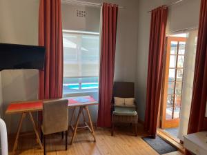 a dining room with red curtains and a table and chairs at Cape Nelson Guest House in Cape Town