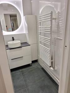 a white bathroom with a sink and a mirror at Chambre d'hôtes Paris La défense Arena in Puteaux +11 photos