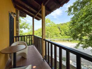a balcony with a table and a view of a river at Pliades Traditional Guesthouse in Palaios Panteleimon
