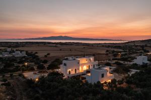 a sunset over a town with a white building at Aurea Blu studio 15 Pure nature, relaxation, sea and sun in Aliko Beach