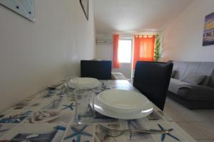 a dining room table with plates and glasses on it at Apartman Ksjusa in Sutomore