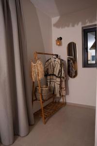 une pièce avec une chaise avec une couverture et un miroir dans l'établissement Palm Suites, à Nea Vrasna