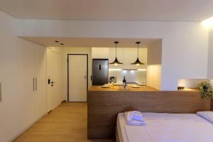 a bedroom with a bed and a bathroom with a sink at Anna's Lovely Corfu Studio in Corfu