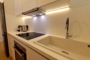 a kitchen with a sink and a stove top oven at Anna's Lovely Corfu Studio in Corfu +24 photos