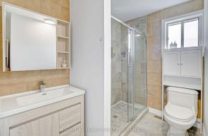 a bathroom with a toilet and a sink and a shower at Elegant 6BR Grand Villa in Highland Hill in Toronto +20 photos