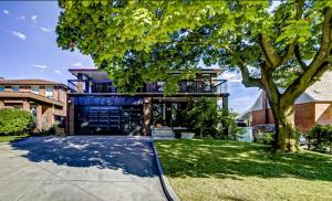 a house with a ramp in front of a tree at Elegant 6BR Grand Villa in Highland Hill in Toronto