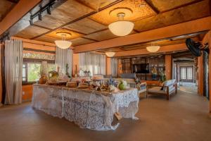 una gran sala de estar con una mesa con comida encima. en Dayo Hotel, en Flecheiras