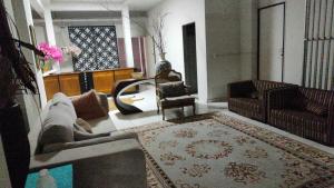 a living room with a couch and a chair at Hostel Nova Jerusalém in Cianorte