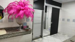 a bathroom with a large pink flower on the wall at Hostel Nova Jerusalém in Cianorte