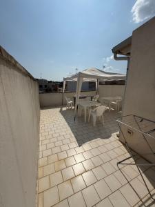 Un patio con mesas y sillas en un tejado. en Casa Pianalto, en Tricase