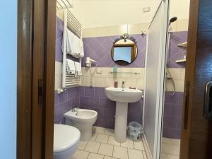 Un baño morado con lavabo e inodoro. en Casa Pianalto, en Tricase 17 fotos más