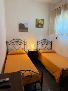 una habitación con dos camas y una mesa y un escritorio en Casa Pianalto, en Tricase