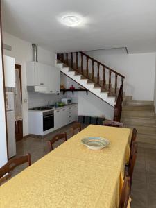 Una cocina y un comedor con una mesa y una escalera. en Casa Pianalto, en Tricase