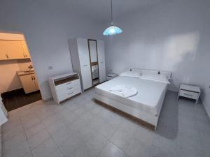 a bedroom with a white bed and a mirror at Studio-apartments, rooms with kitchen in Golem