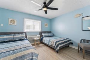 a bedroom with two beds and a ceiling fan at 301 Ocean Ave, Unit 206 - The Harbor Light in North Wildwood +15 photos