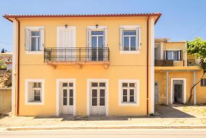 a yellow house with a balcony on a street at Aleka's traditional house in Ambelófiton
